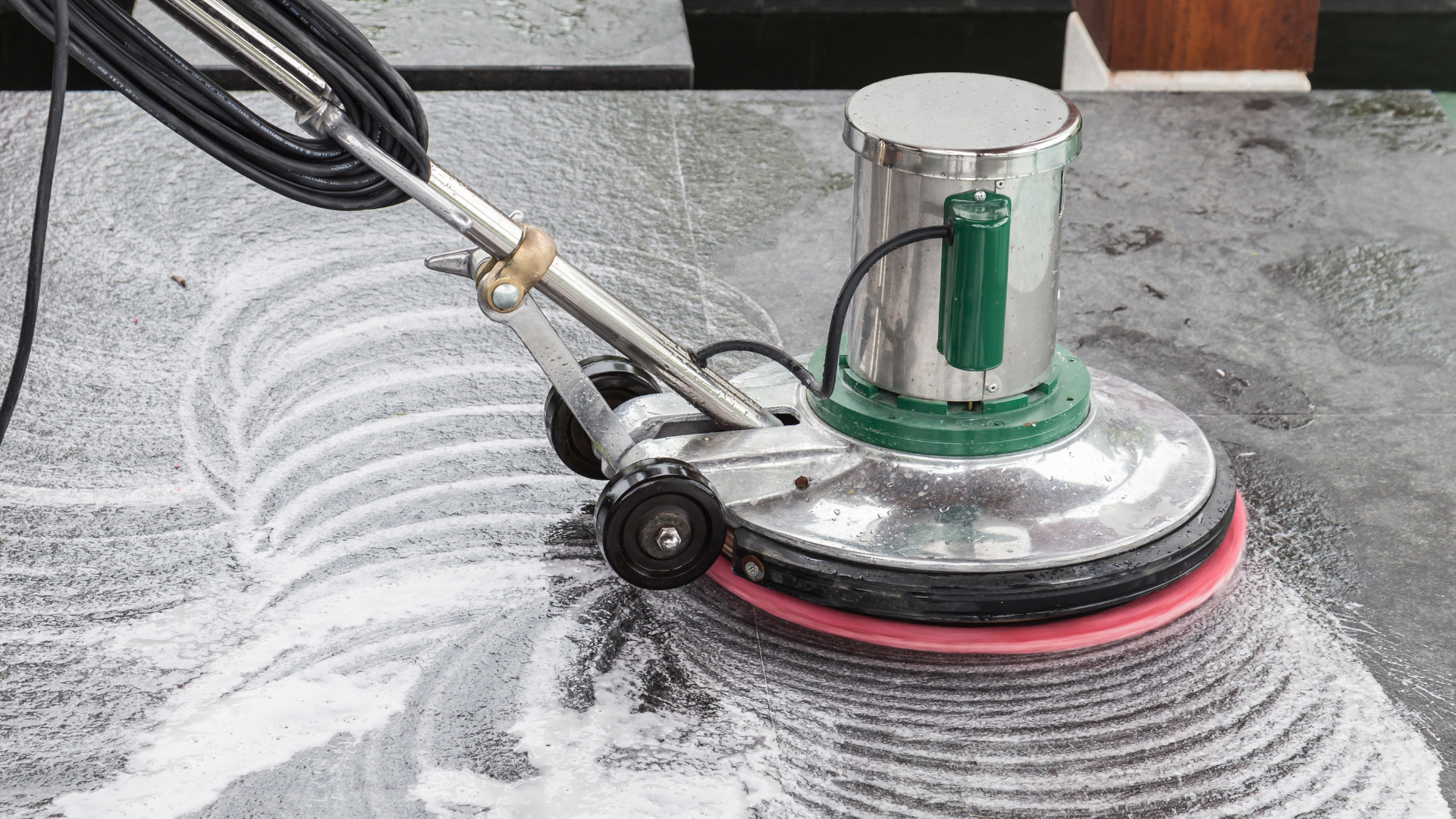 A close up of a wet floor with a machine